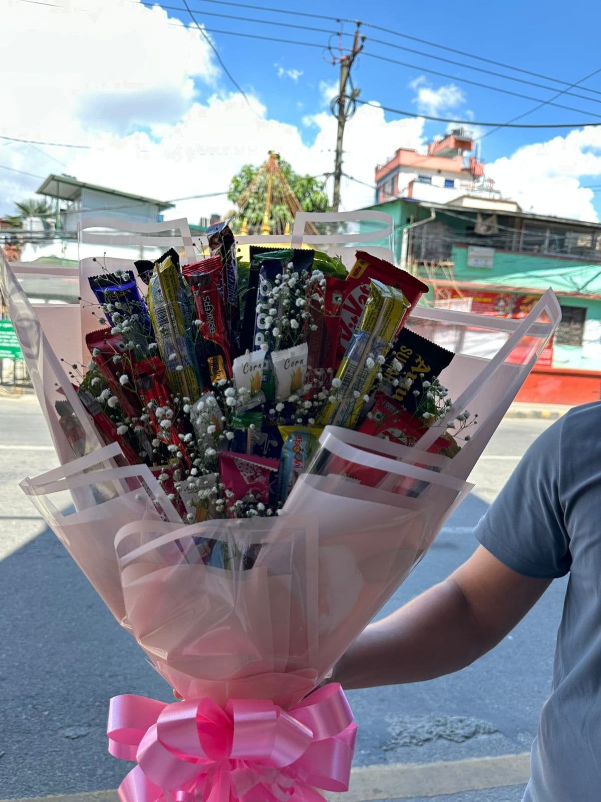 Assorted chocolate and snack bouquet in pink wrapping