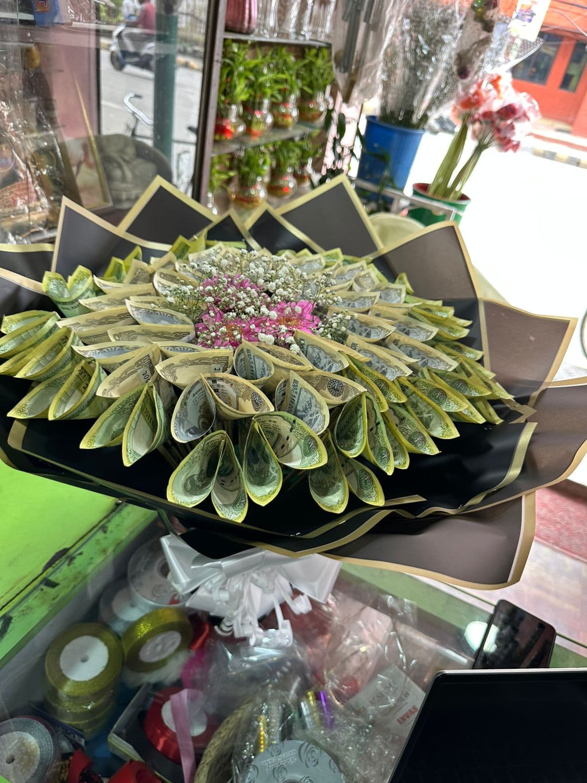 Decorative money bouquet with pink flowers and baby's breath