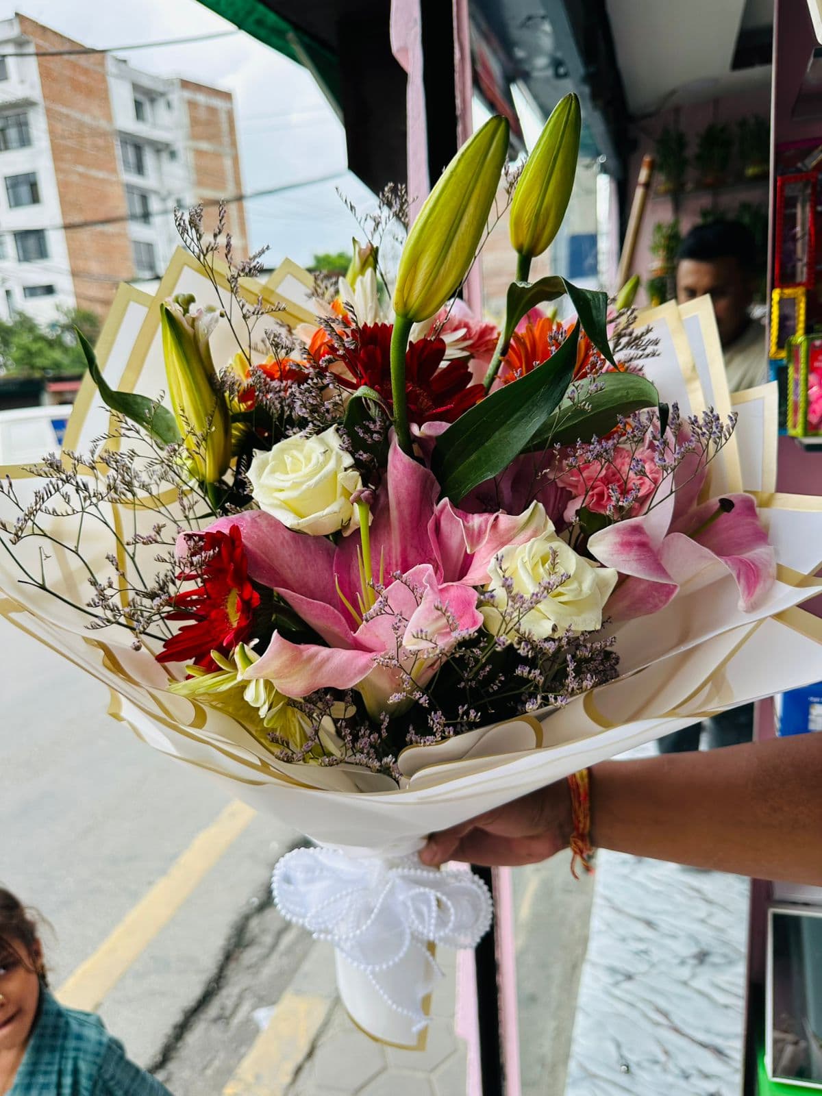 Pink lilies, white roses, and colorful gerberas in a garden bouquet